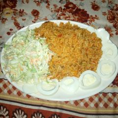 A picture of Jollof rice with coslow.