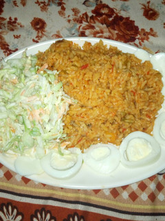 A picture of Jollof rice with coslow.