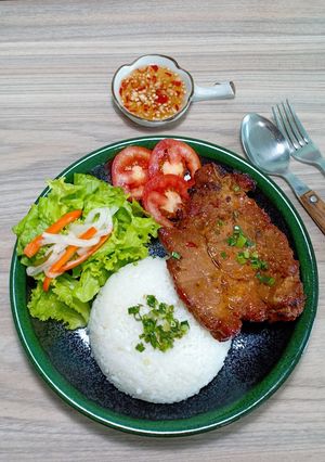 A picture of Vietnamese Broken Rice with Honey Grilled Pork Chops (Cơm tấm sườn nướng mật ong).