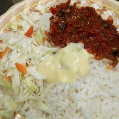 A picture of White rice and stew with cabbage and cream.