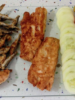 Una foto de Pescado variado frito y ensalada de tomates con pepinos