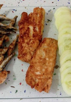 Una foto de Pescado variado frito y ensalada de tomates con pepinos