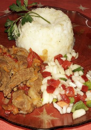 Una foto de Carne salteada con mini budín de arroz y ensalada