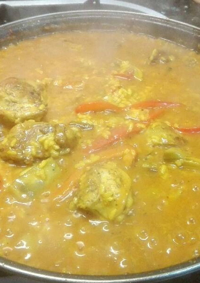 Una foto de Paella de conejo, alcachofas y ajos tiernos