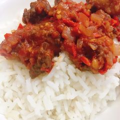 A picture of White rice and tomato sauce with beef.