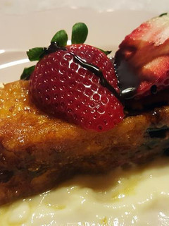 Una foto de Torrijas bañadas en almíbar de naranja sobre crema inglesa