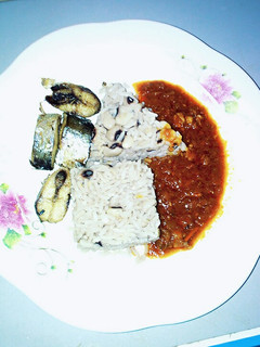 A picture of Rice and beans with stew.