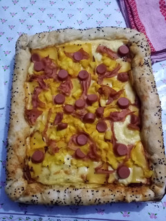 Una foto de Pizza hawaiana con salchichas y queso americano