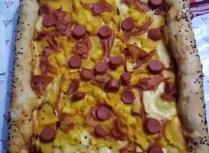 Una foto de Pizza hawaiana con salchichas y queso americano