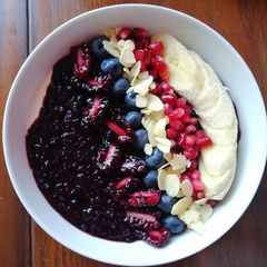 A picture of Black rice porridge with greek yoghurt,fruits and flaked almonds.
