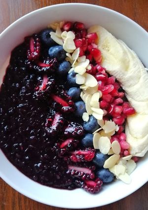 A picture of Black rice porridge with greek yoghurt,fruits and flaked almonds.