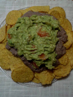 Una foto de Nachos con guacamole y crema de frijoles negros
