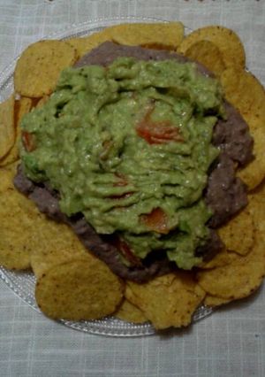 A picture of Nachos with Guacamole and Black Bean Cream.