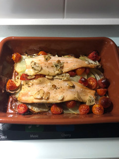 Una foto de Filetes de trucha al horno sobre cama de patatas, cebolla y tomate