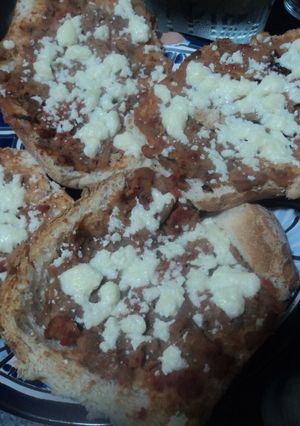 Una foto de Tostaditos de bolillo con frijoles con carne y queso gratinados