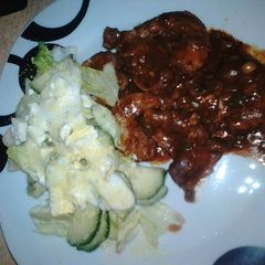 A picture of Chillies chicken gizzards & necks served with green salad.