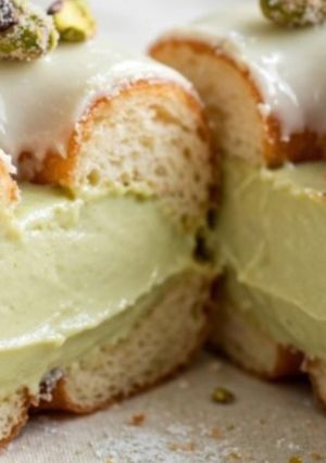 Una foto de Donuts de pistacho con crema de pistacho, glaseado de chocolate blanco y pistachos azucarados