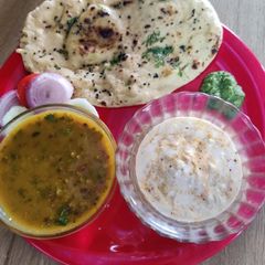 A picture of Punjabi thali (Tandoori roti with dal makhni kheere ka raita and chutney).