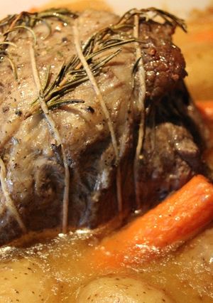 A picture of Hearb roasted leg of lamb roll with potatoes and carrots.