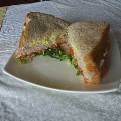 Una foto de Sándwich de huevo, jamón y tomate con lechuga - Triple