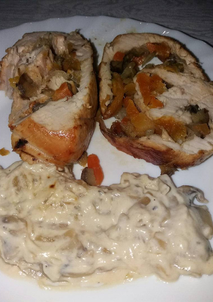 Una foto de Pechuga de pavo rellena acompañada con salsa de champiñones
