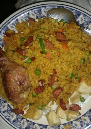 A picture of Tasty curried Fried rice with Barbecued chicken and Banana.