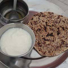 A picture of Onion parantha curd and ghee.