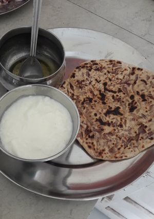 A picture of Onion parantha curd and ghee.