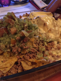 Una foto de Nachos con carne picada, quesos y guacamole