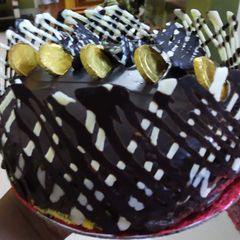 A picture of Gold coin chocolate truffle eggless cake.