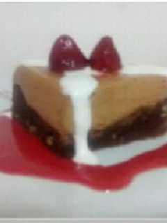 Una foto de Torta de chocolate con mousse de dulce de leche y salsa de frutilla.
