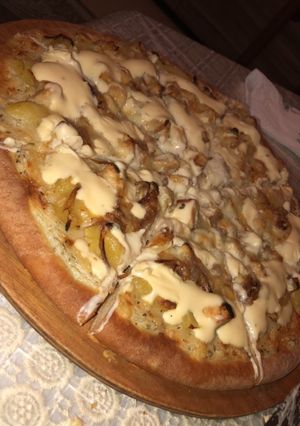 Une photo de Pizza pomme de terre/ poulet et sa sauce fromagère