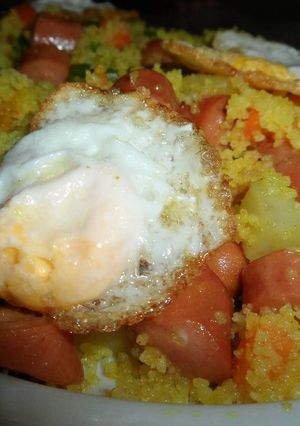 Una foto de Cous cous al ras hanout con verduras y frankfurt