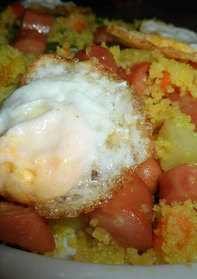 Una foto de Cous cous al ras hanout con verduras y frankfurt