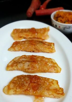 A picture of Gajar R Patisapta (Eggless Sweet Carrot Crepes Stuffed with Carrot Pudding and Served with Carrot Syrup).