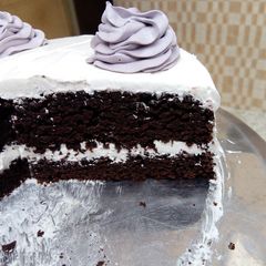 A picture of Whipped cream frosted chocolate cake.