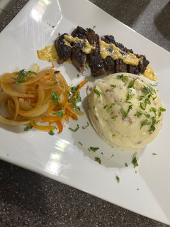 Una foto de Papás majas con bacon, queso y un New York Steak well done