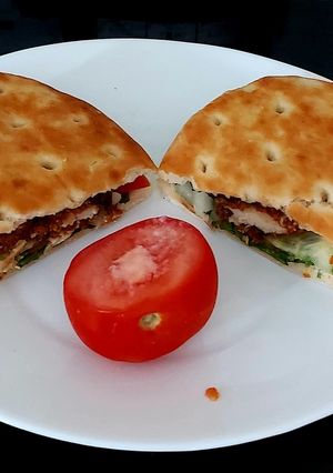 A picture of My Buttermilk coated chicken on Soft Focaccia Bread with Salad.