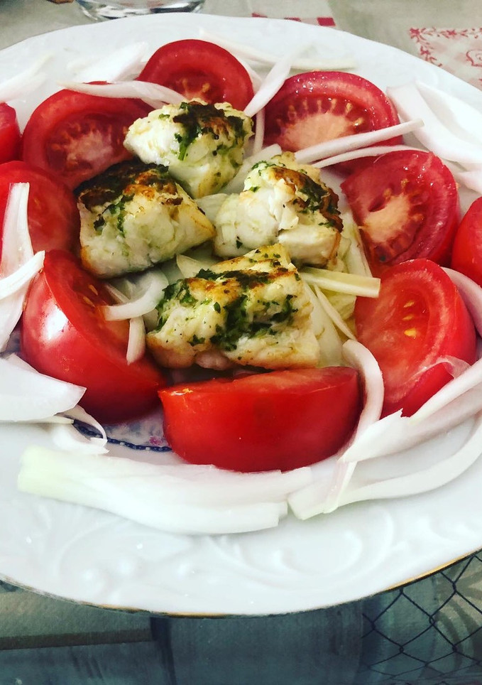 Una foto de Rape a la plancha con guarnición de tomate y cebolla