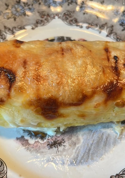 Una foto de Plátano macho maduro o bananas rellenas de carne cubiertas de queso