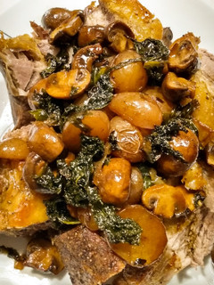 A picture of One pan roasted pork, potatoes, mushrooms, kale and pan gravy.