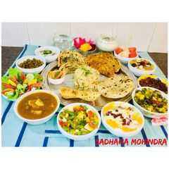 A picture of Green Channa-Cheese Curry,Methi -Aloo,Fruit Yogurt,Sautéed Veg,Mint Riata,Rice,fresh fruits,Lassi.