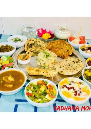 A picture of Green Channa-Cheese Curry,Methi -Aloo,Fruit Yogurt,Sautéed Veg,Mint Riata,Rice,fresh fruits,Lassi.