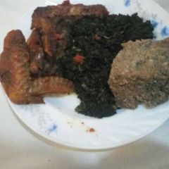 A picture of Brown ugali greens and chicken.
