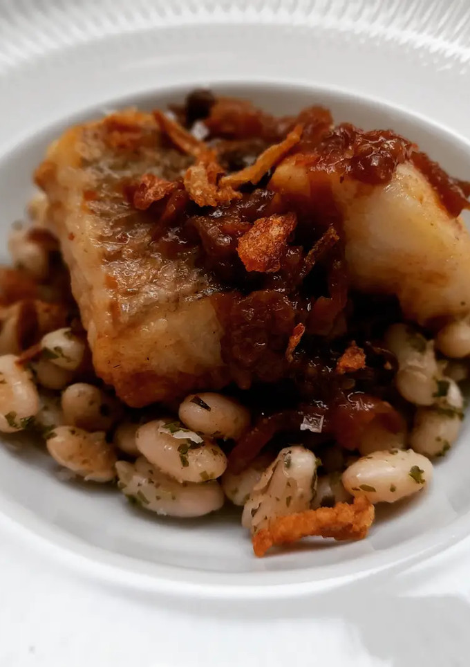 Una foto de Merluza en salsa de cebolla y moixernons con fessolets