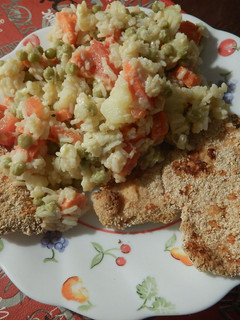Una foto de Milanesa de pollo con papas, zanahoria, tomate, arvejas y arroz