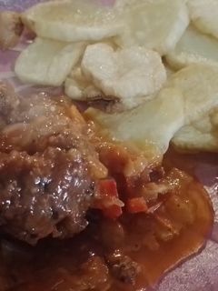 Una foto de Albóndigas con queso cremoso adentro y papas fritas