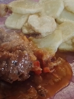 Una foto de Albóndigas con queso cremoso adentro y papas fritas