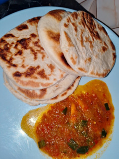 A picture of Naan bread with pumpkin soup.