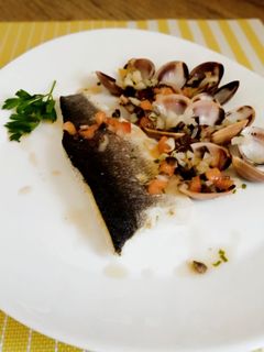 Una foto de Lubina con almejas y vinagreta